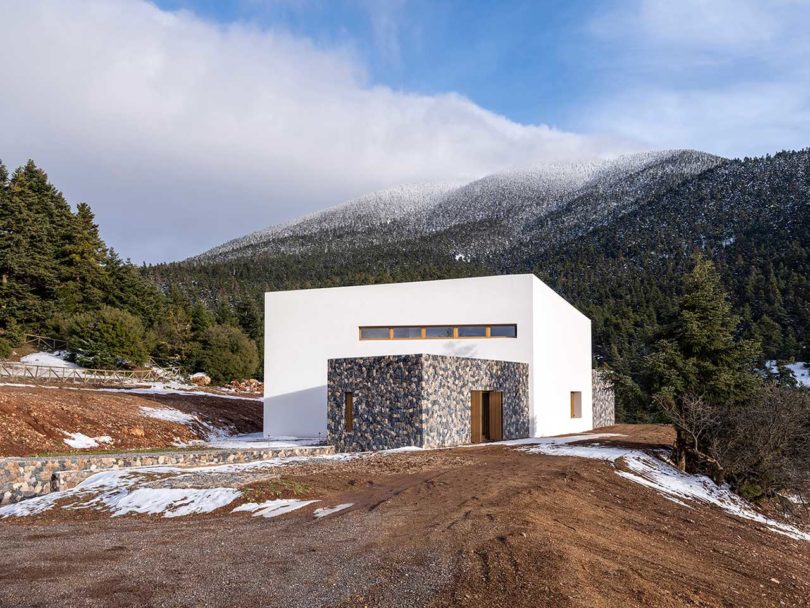 view of modern stone and white mountain house