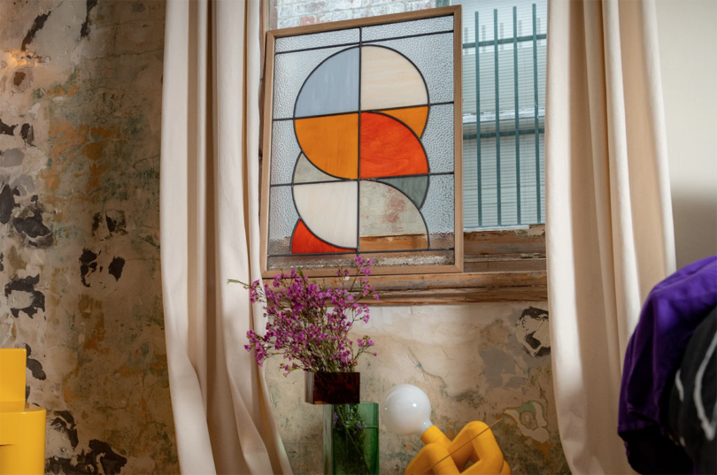 styled interior space with modern stained glass hanging in the window