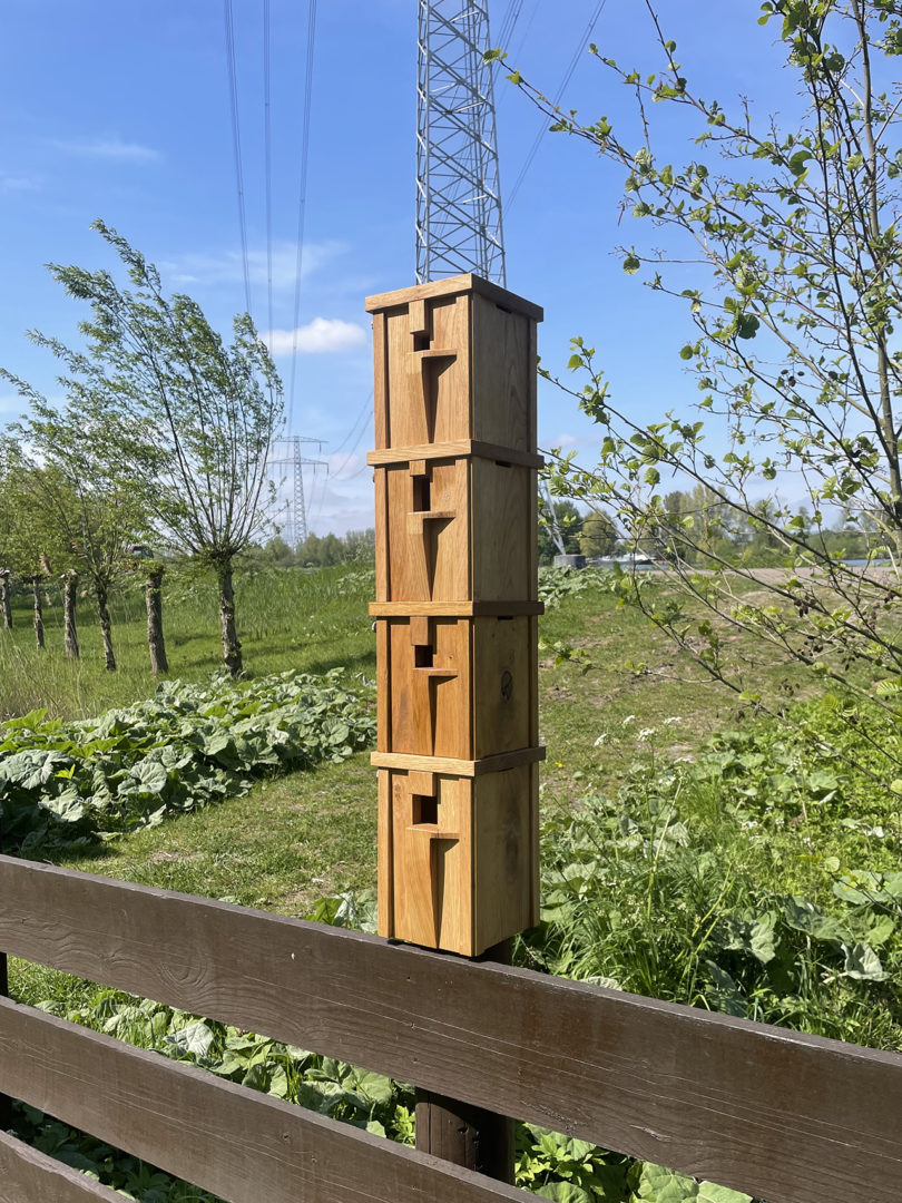 four stacked modern wood bird nesting boxes outdoors