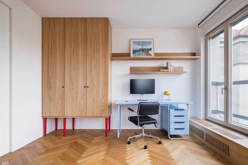 Modern interior of room with small desk and chair, and large wooden cabinet