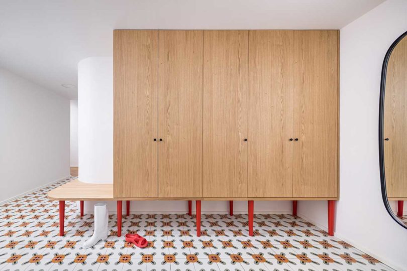 Wall of wooden built-in cabinets with red legs