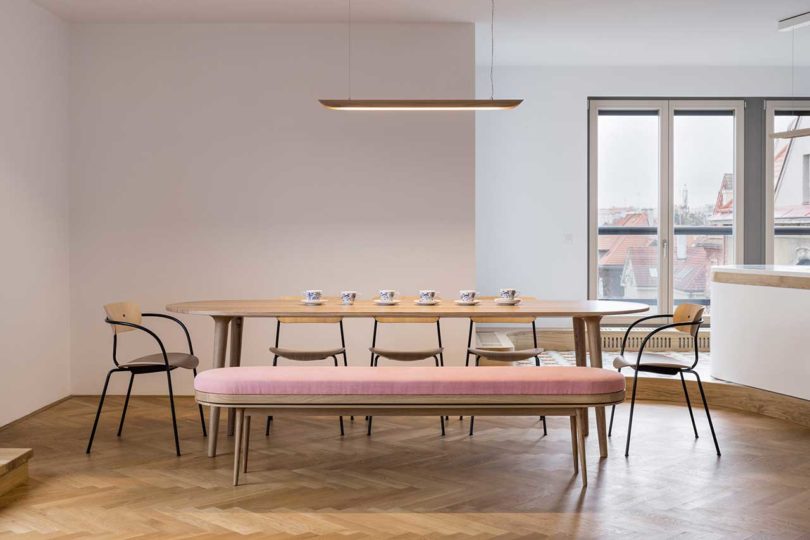 Modern interior view of dining room with long wood table and bench seat