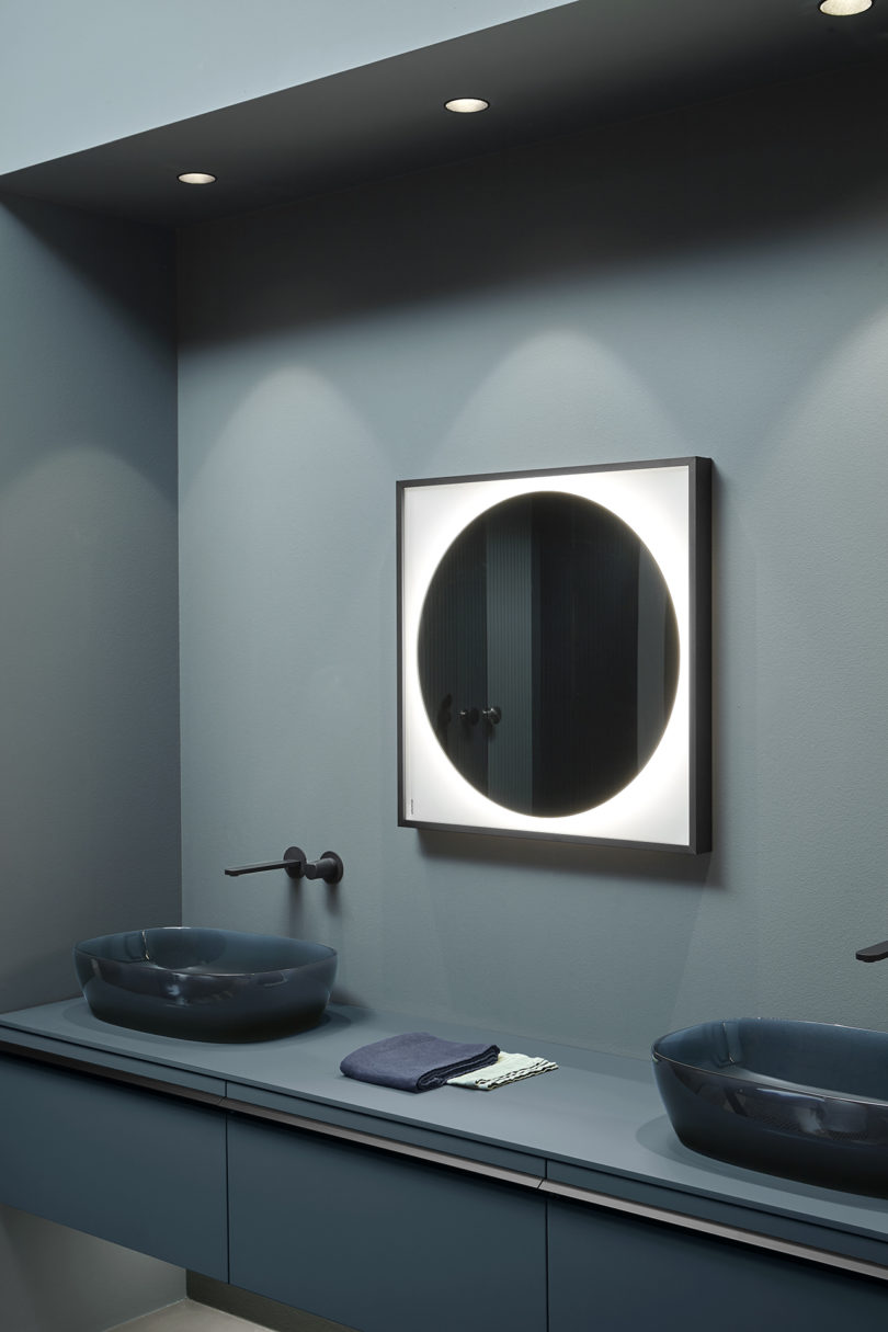 bathroom vanity with two illuminated mirrors