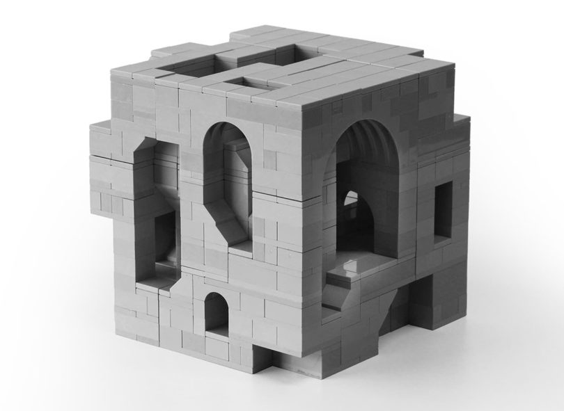 A Soma cube model in angle view, a geometric puzzle invented by mathematician Piet Hein in 1933, recreated with gray LEOG pieces shown against all-white background,