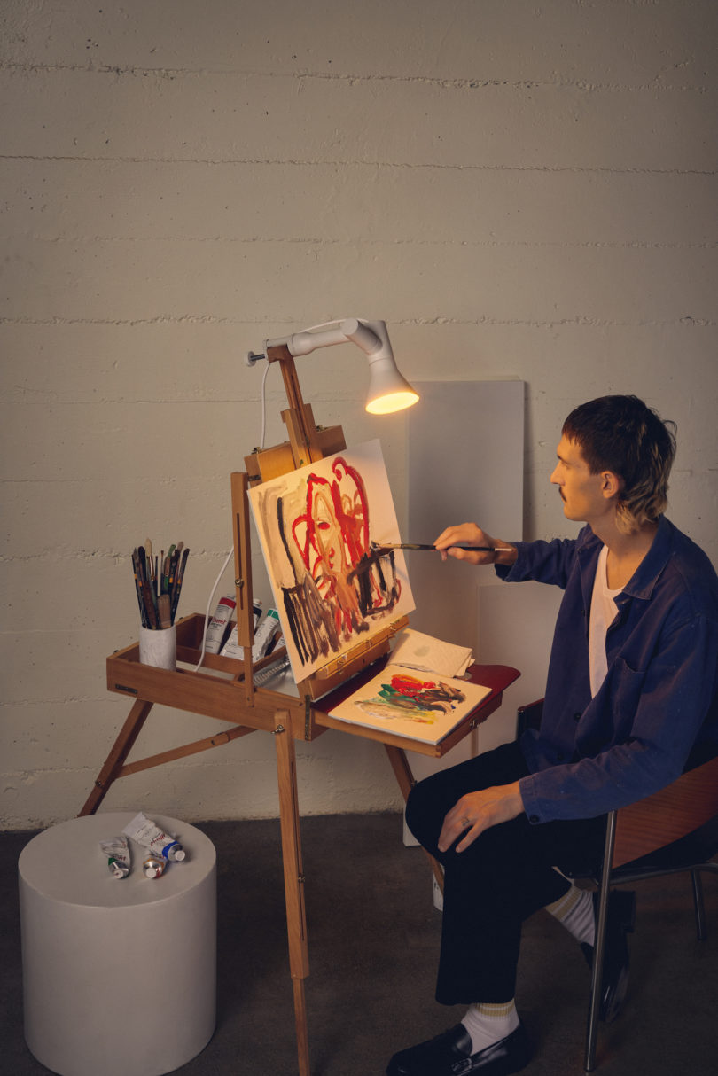 clamp light on easel next to artist