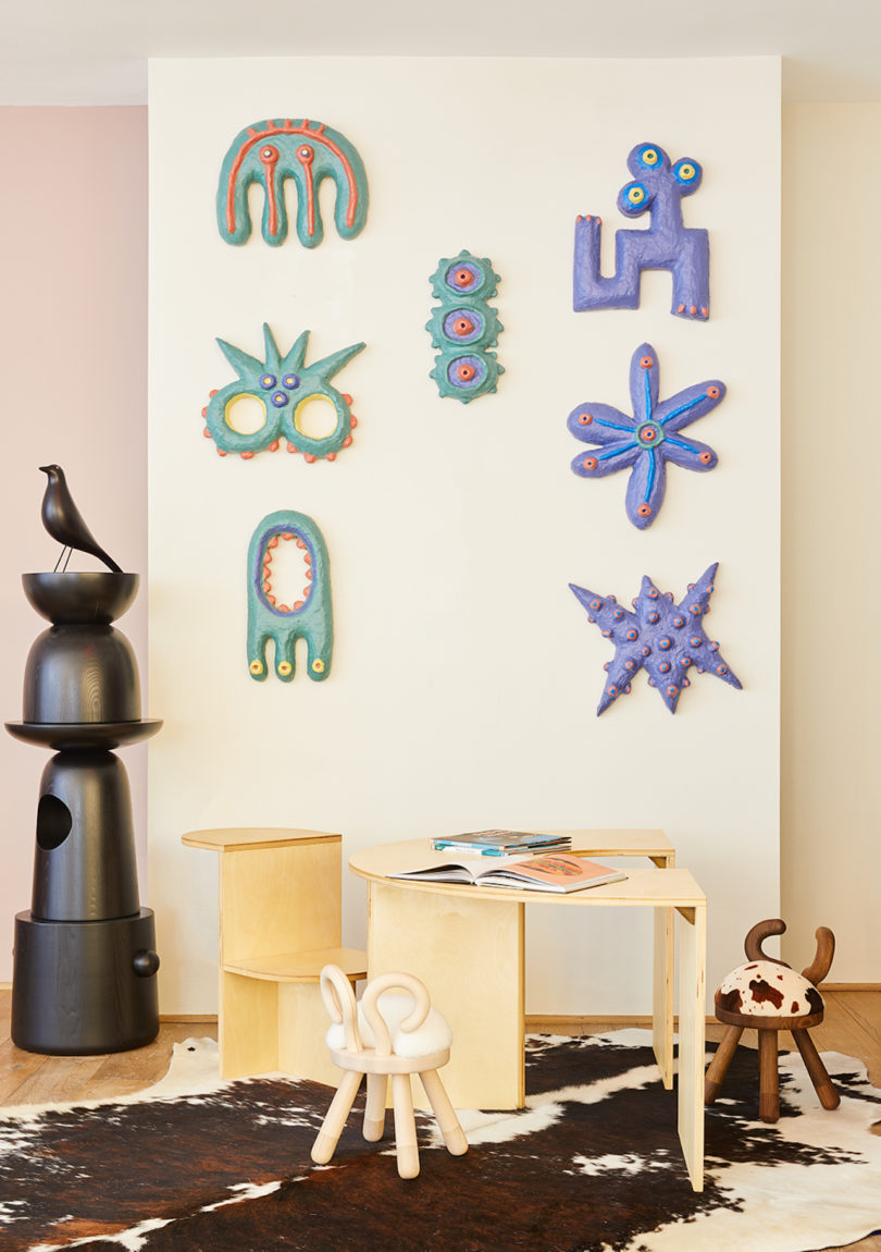 playful green and purple sculptures on wall