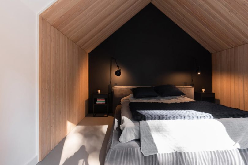 view into pitched roof bedroom nook with black wall