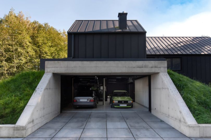 side exterior view of modern house with concrete garage under hill