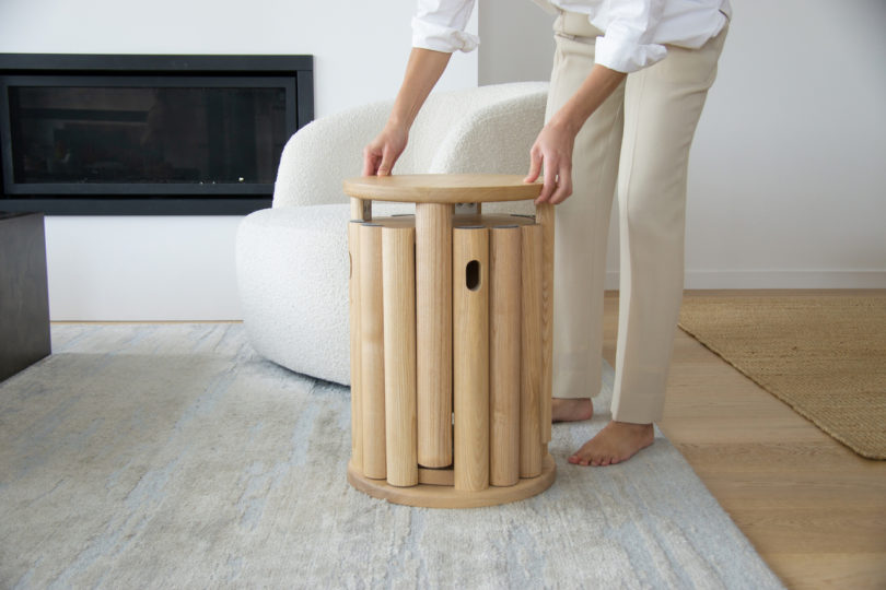 person lifting stool from side table
