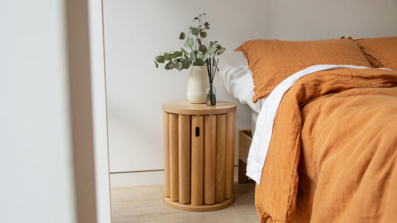 wooden side table next to bed