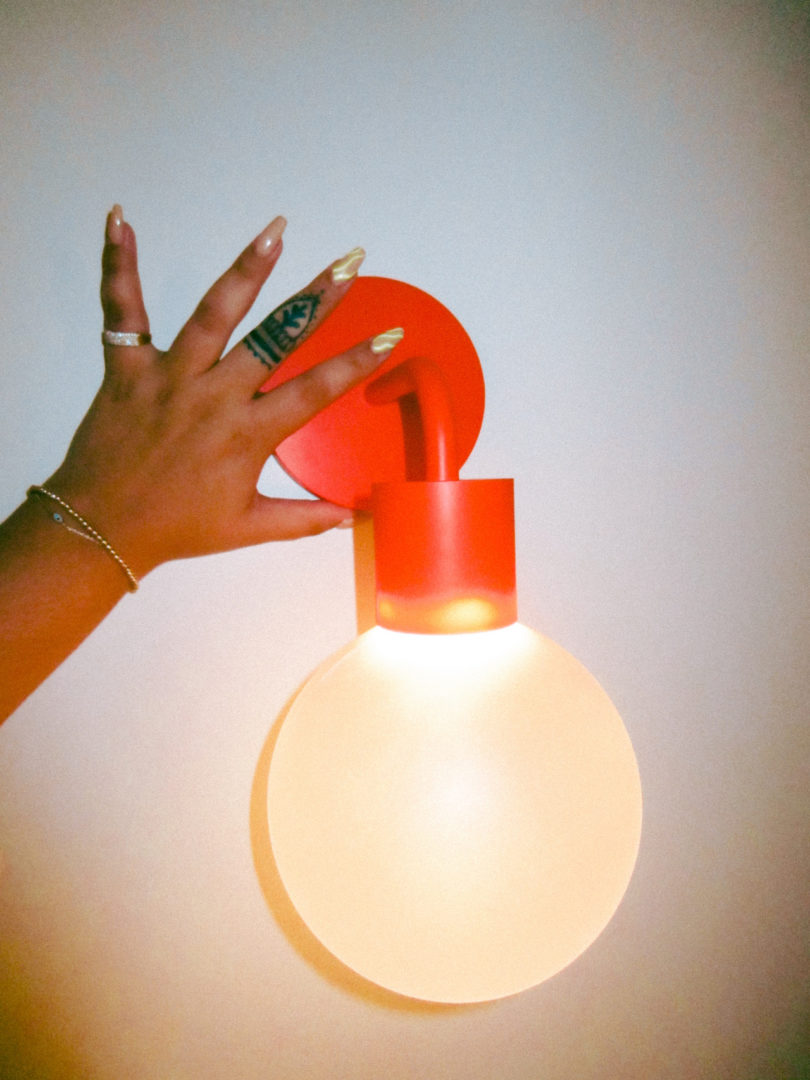 hand touching red wall light