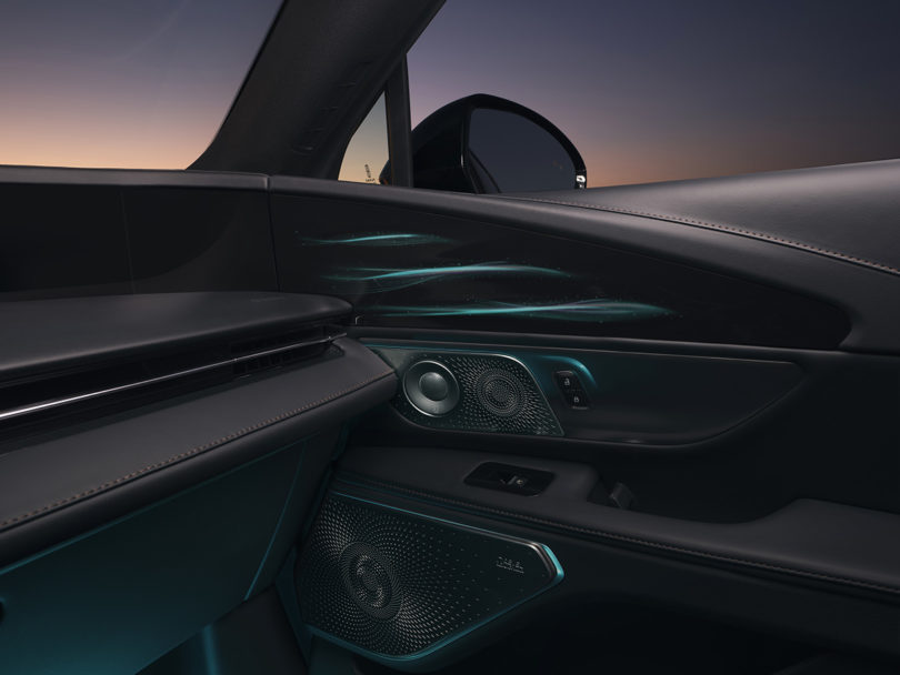 Two of the twenty-eight speakers of the Revel Ultima 3D Audio System set on passenger door, with dusk light in the background.