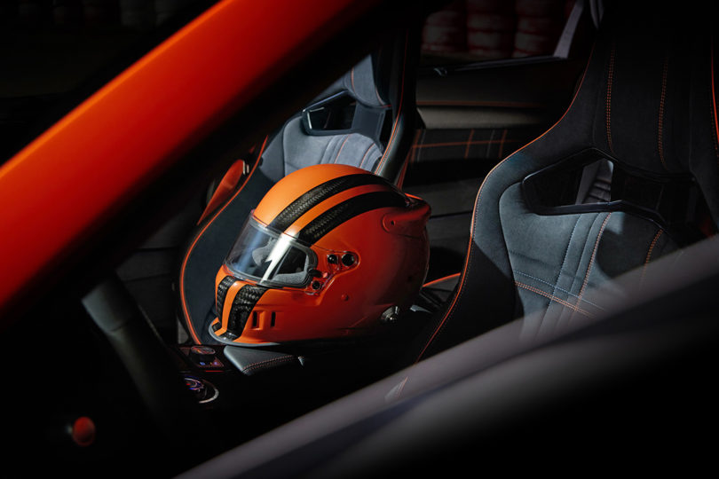 Red orange Genesis GV80 Coupe Concept interior with racing helmet on seat.