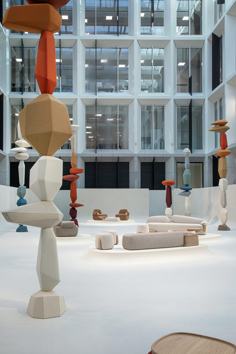 site specific installation with colorful towers of stacked objects and light grey seating furniture