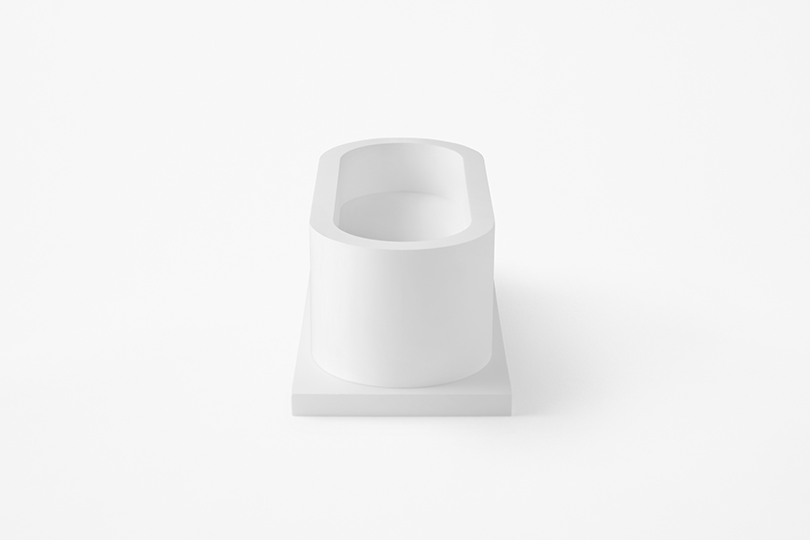 side view of white concrete tub turning into chair