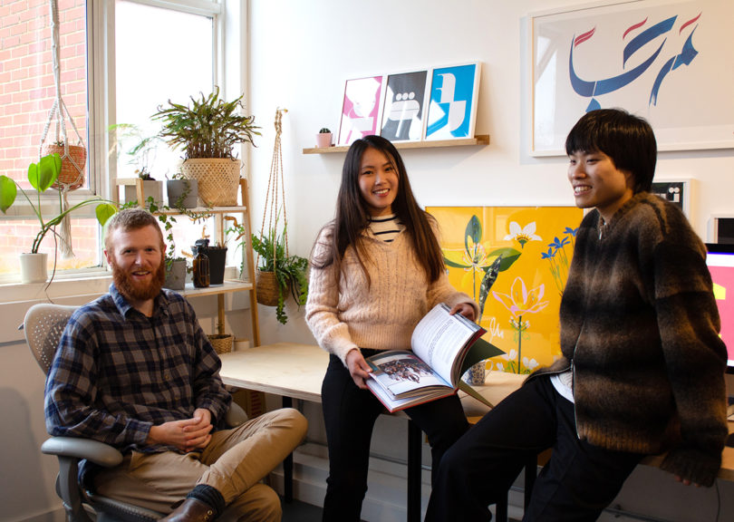 three people posing for a photo in a design studio