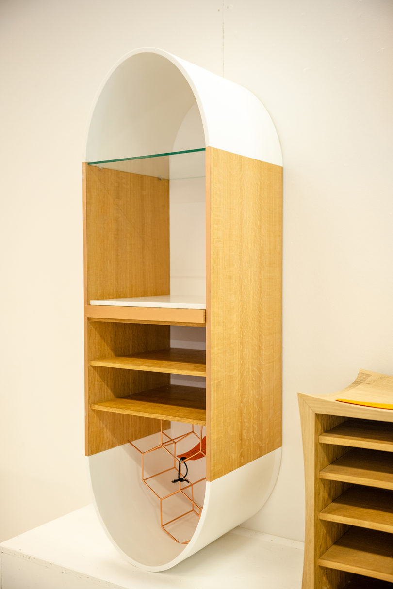 capsule-shaped white and wood hanging shelves