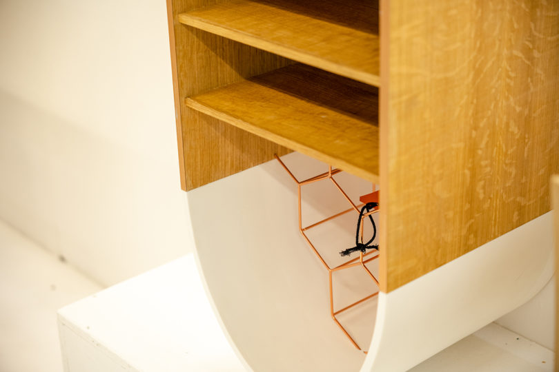 detail of capsule-shaped white and wood hanging shelves