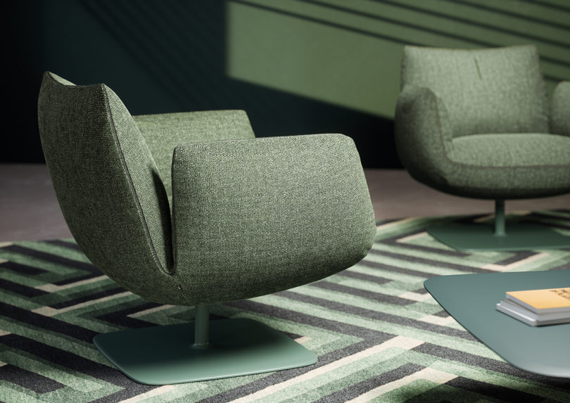 two sage green swivel club chairs in a styled interior space