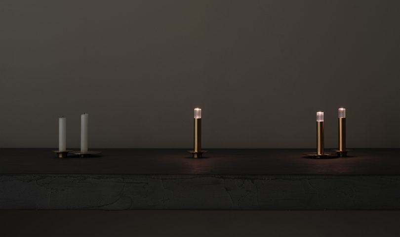 Three brass lights that resemble candle sticks