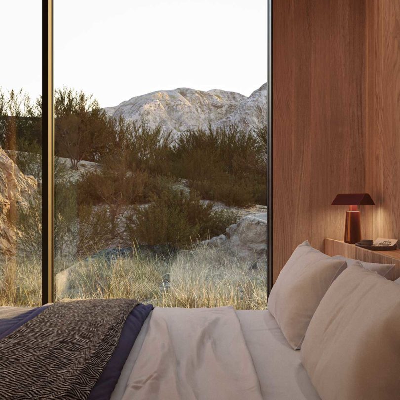 side view of modern bedroom looking over bed through window out to mountains