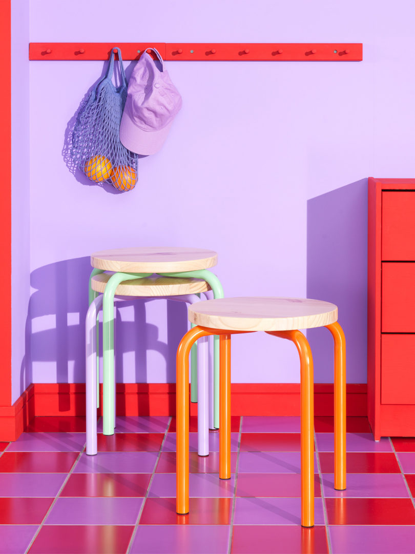 colorful tubular IKEA stools in red and violet wall and checker floor room