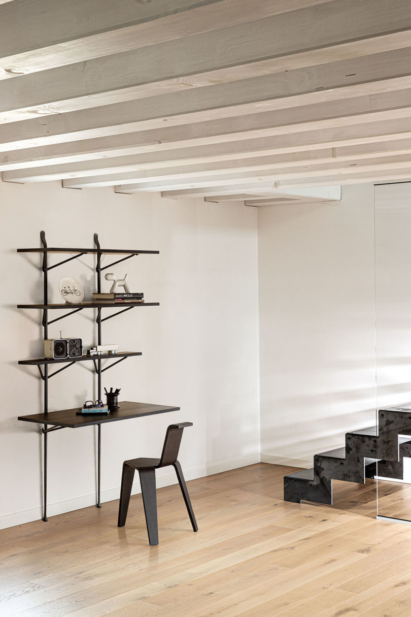modern open wall shelving with built in desk in a styled space