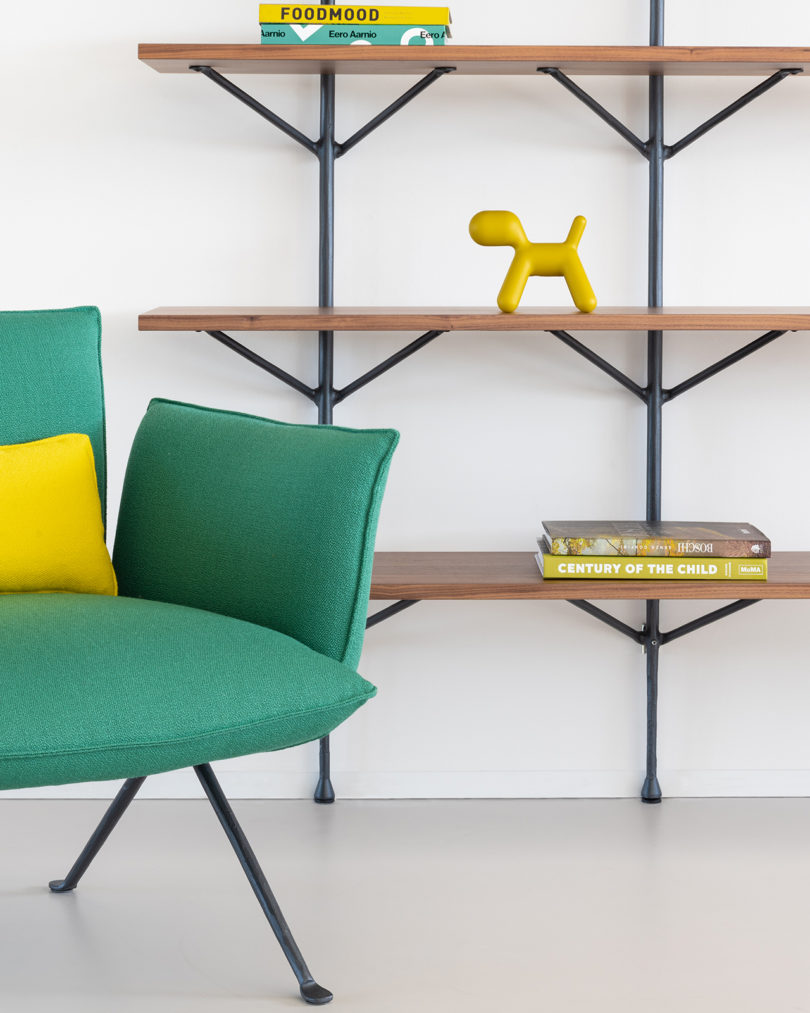 styled modern open wall shelving with a green armchair