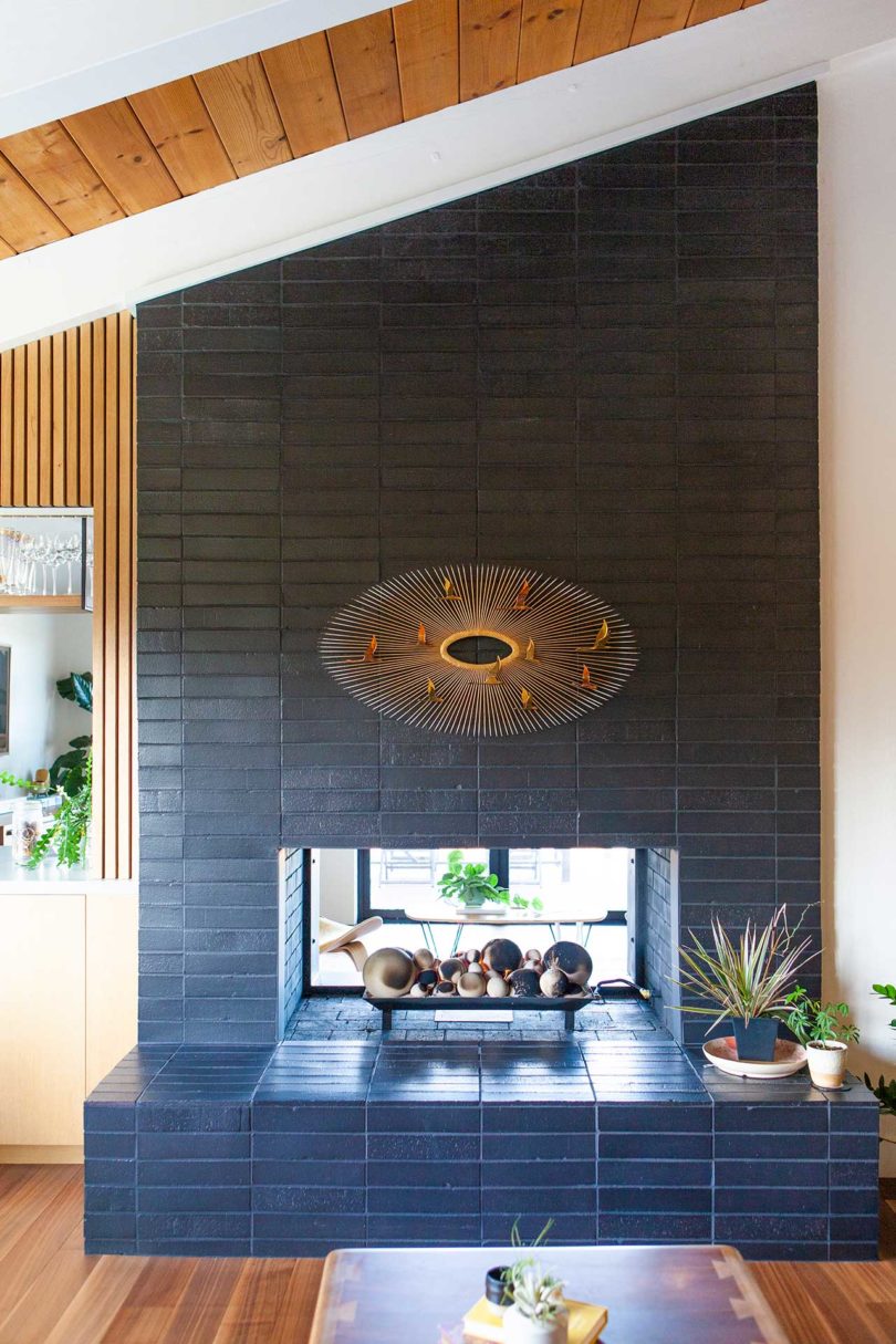 view of angled midcentury fireplace with black tile