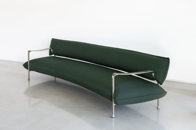 curved modern sofa with silver arms and legs