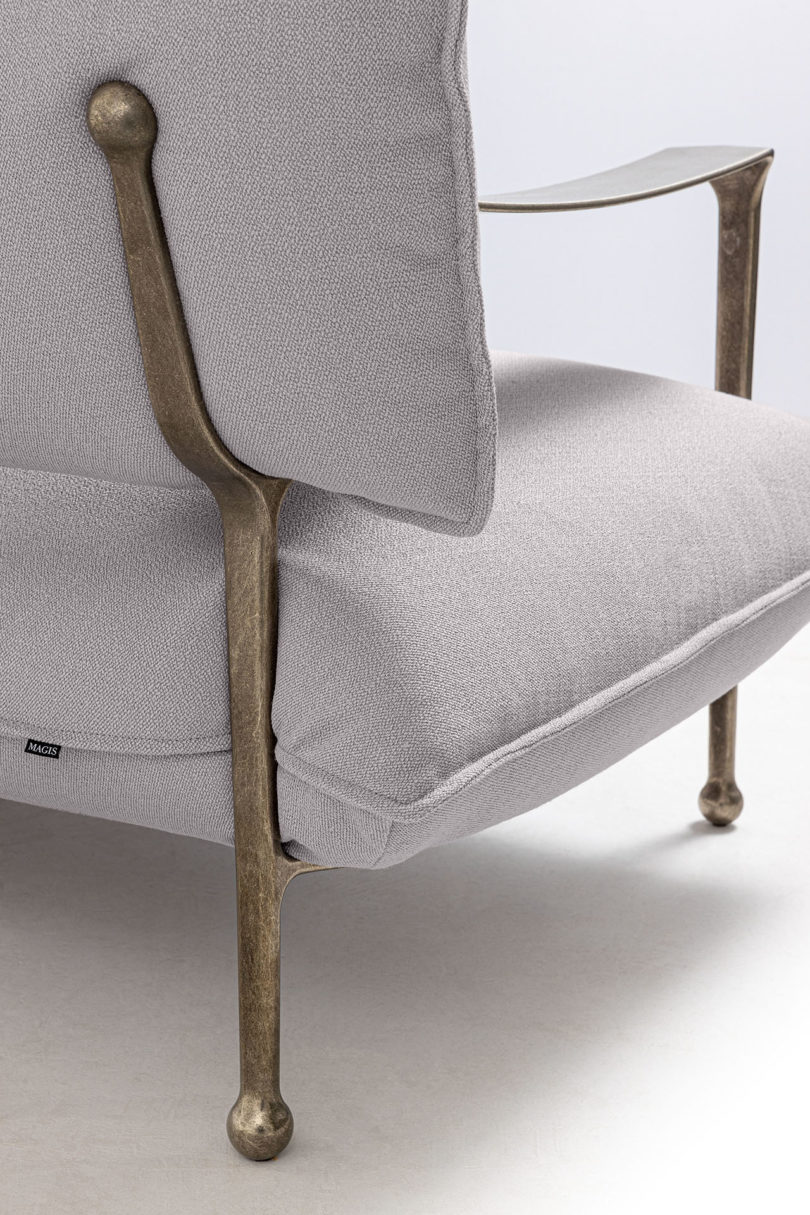 detail of curved modern sofa with silver arms and legs