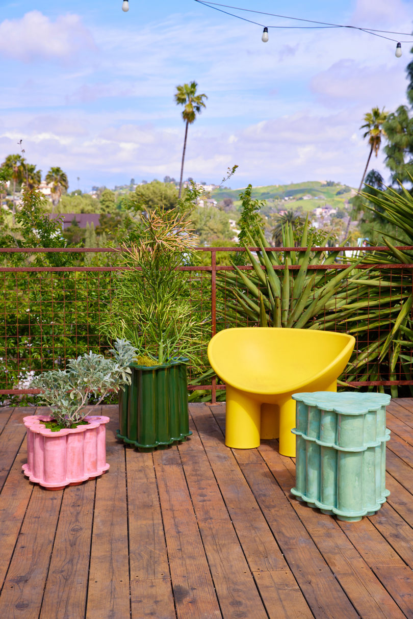 outdoor deck with two planters, a side table, and a chair