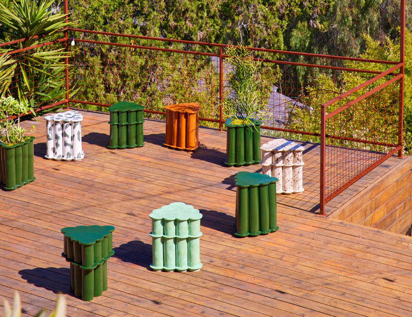 a collection of variously colored modern outdoor tables on a deck