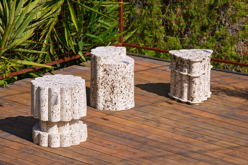 three speckled white outdoor tables on a deck