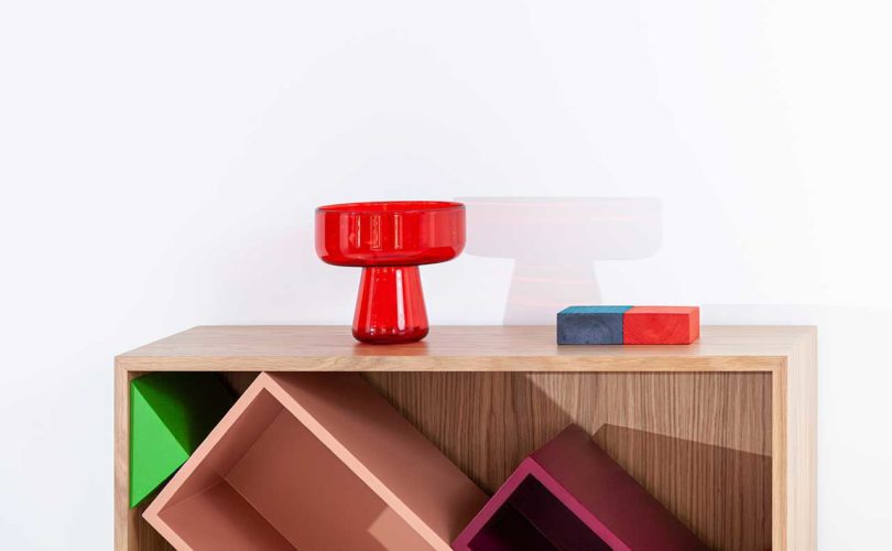closeup partial view of modular storage shelf with colorful geometric boxes inside with red lamp on top