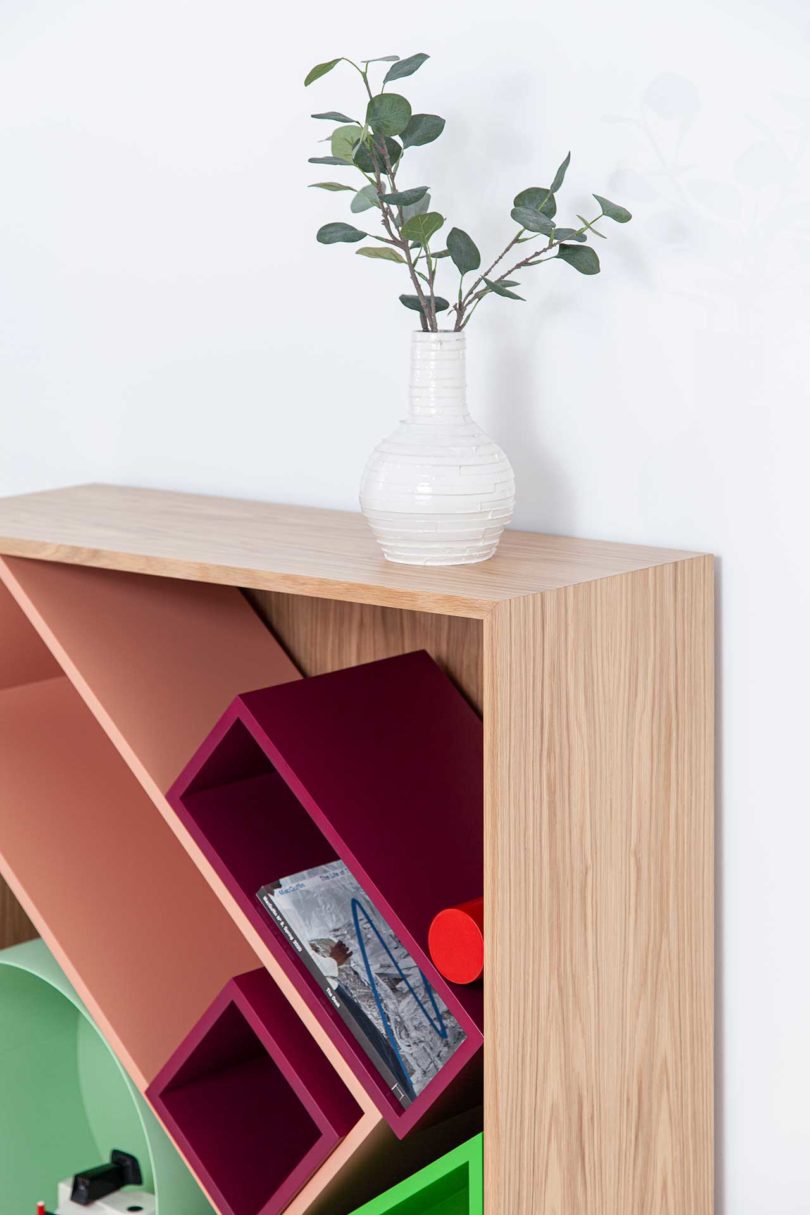 closeup angled view of modular storage shelf with colorful geometric boxes inside