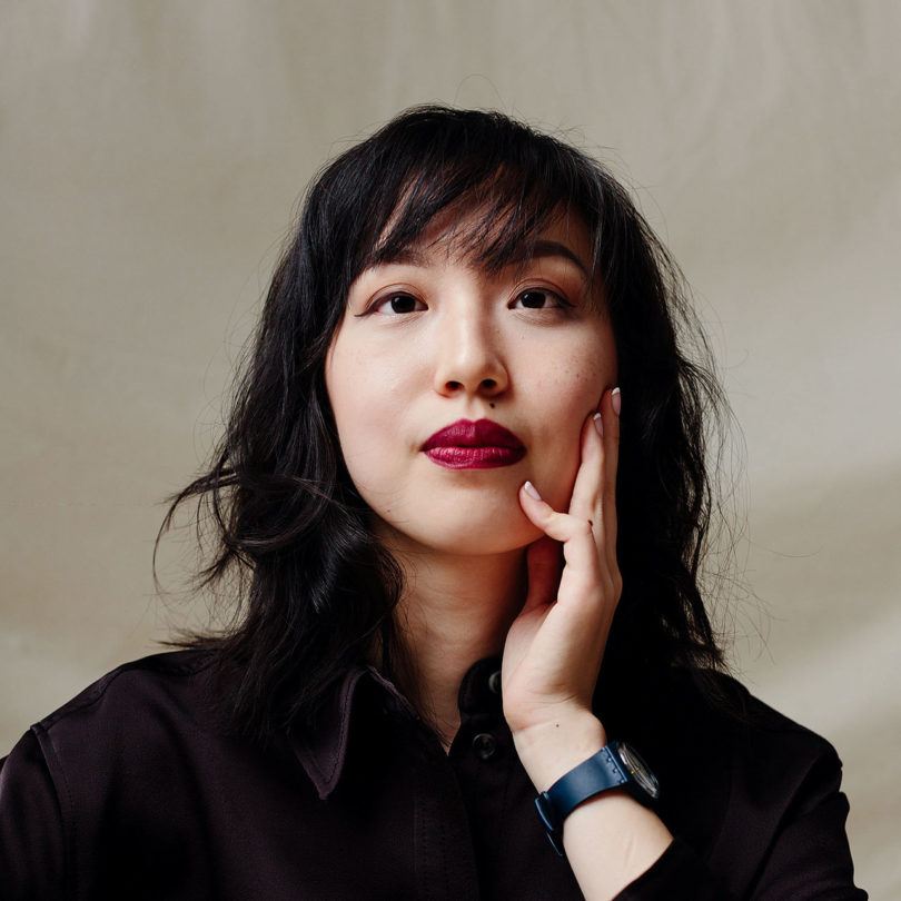 light-skinned black haired woman wearing a black shirt and red lipstick