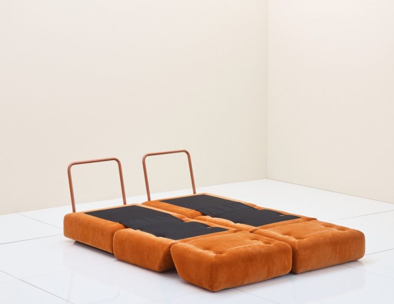 two orange chairs unfolded out into beds
