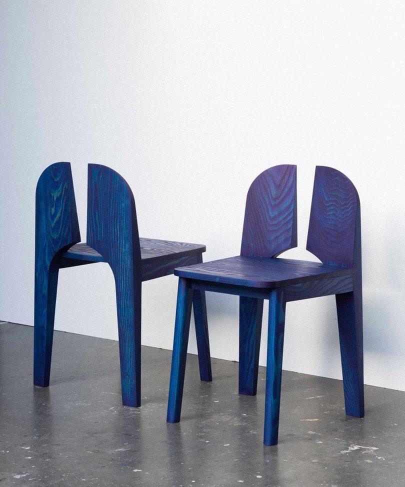 two blue chairs with negative space in the back rests