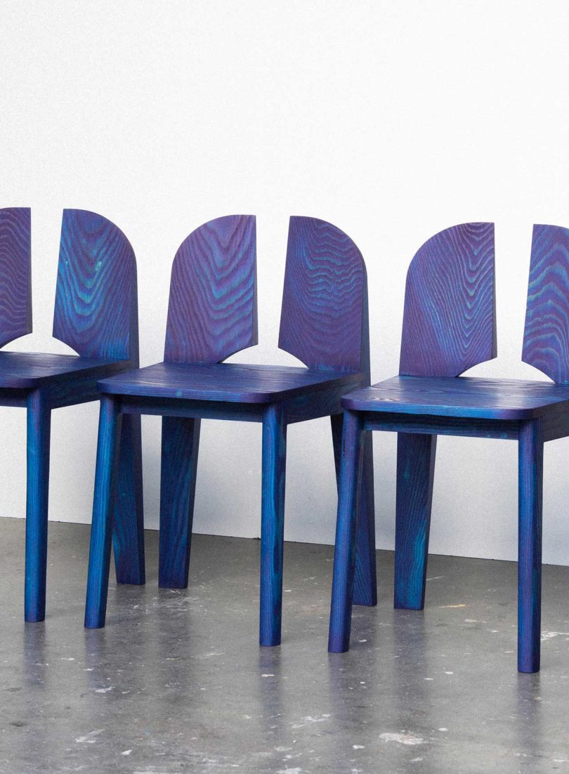 three blue chairs with negative space in the back rests
