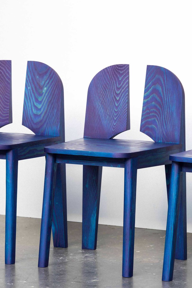 three blue chairs with negative space in the back rests