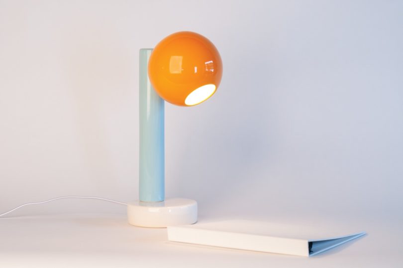 Orange Peel, Light Aqua, Bright White desk lamp next to binder
