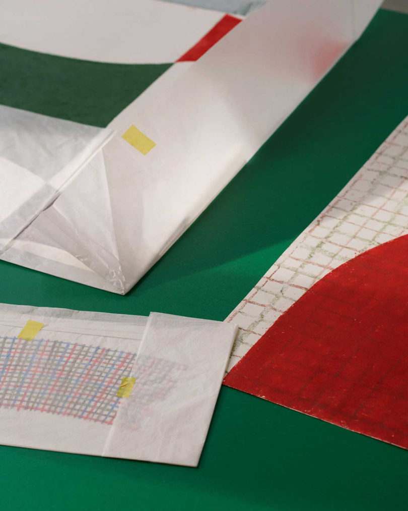 طرح جزئیات طرح های الگوی Marimekko x Finkenauer روی میز سطح سبز.
