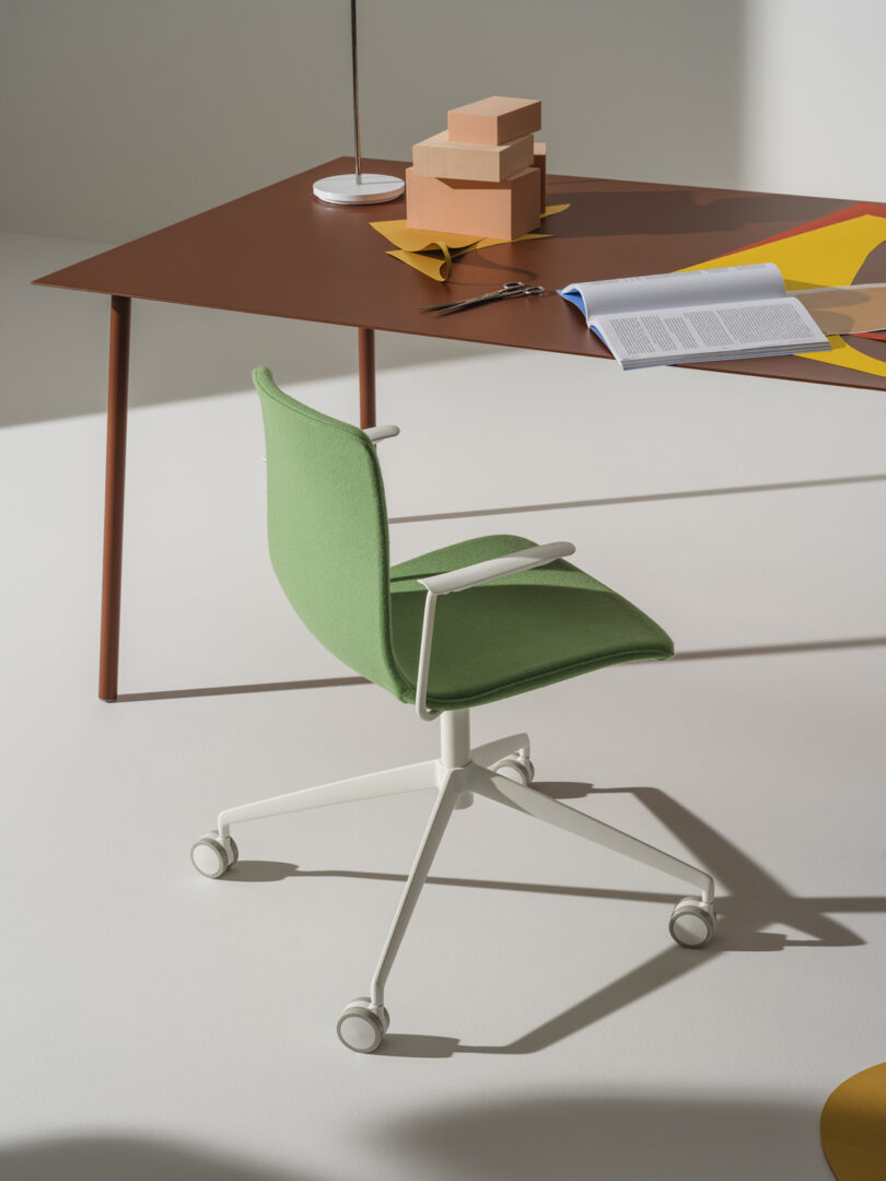 green office chair with wheels in front of a desk