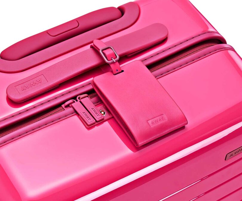 angled down view of top of neon pink suitcase