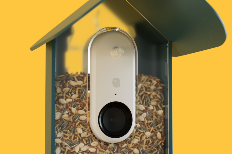 detail of dark blue smart AI camera bird feeders on yellow background