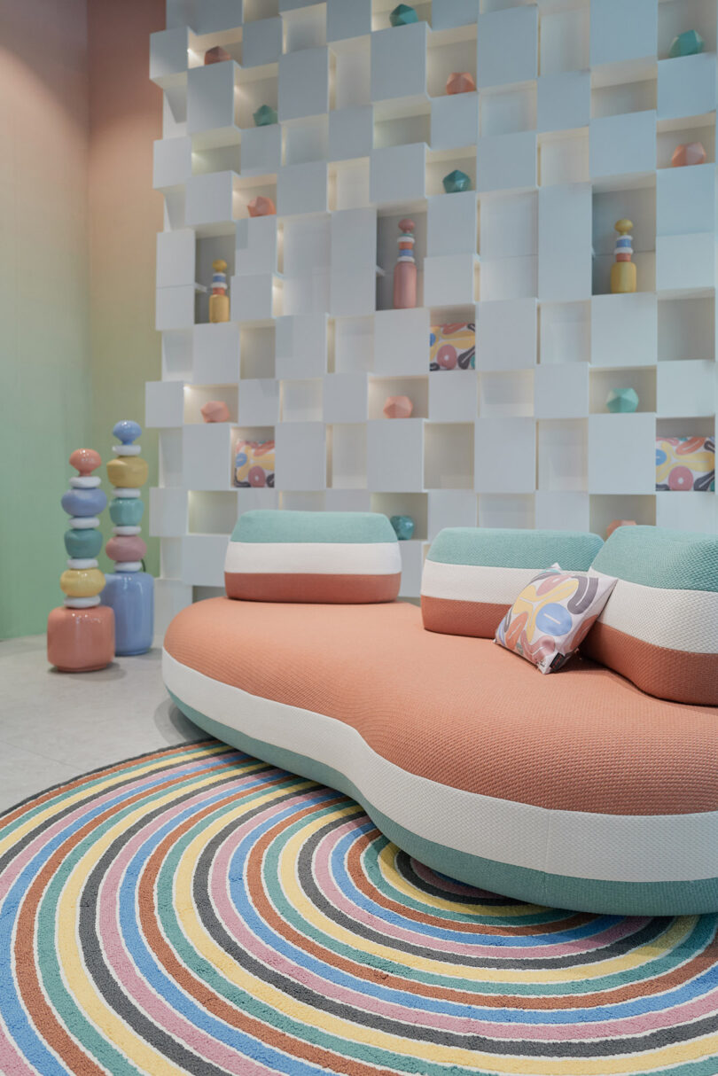 showroom displaying pastel colored organically shaped pouf seating, tables, and rugs