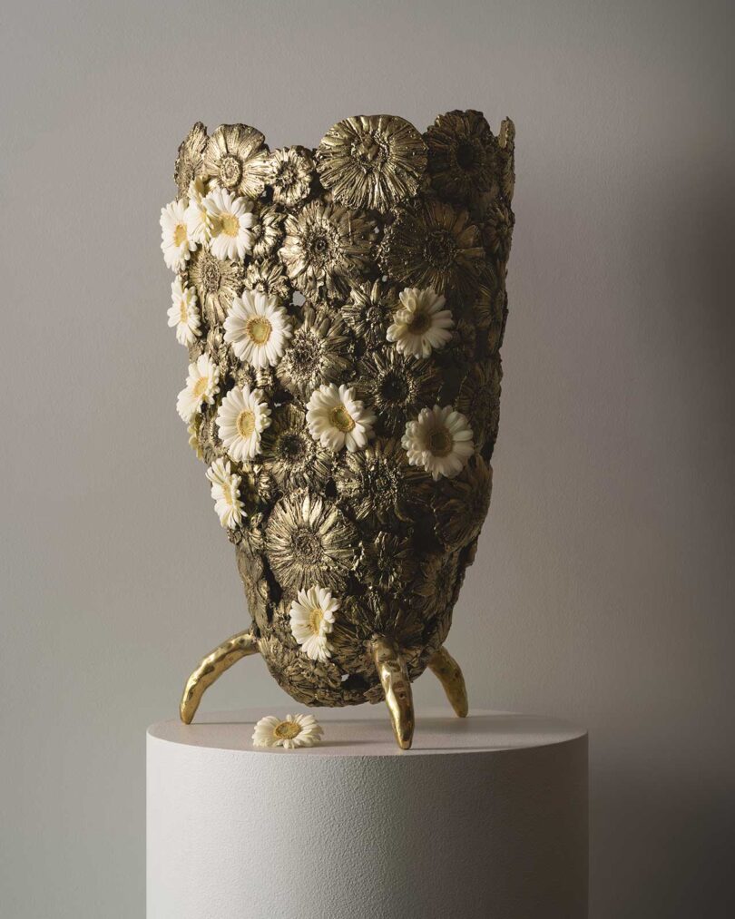 closeup of brass and flower sculptural vase