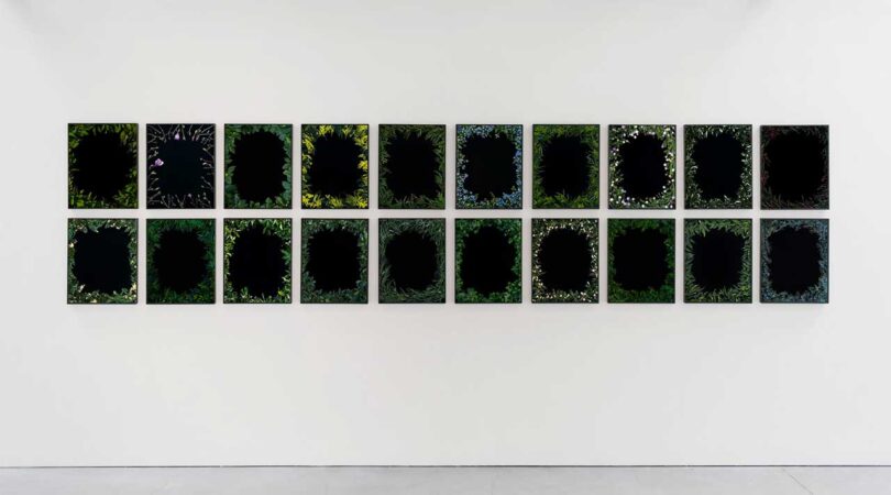 View of double row black photographs framed with flowers and greenery
