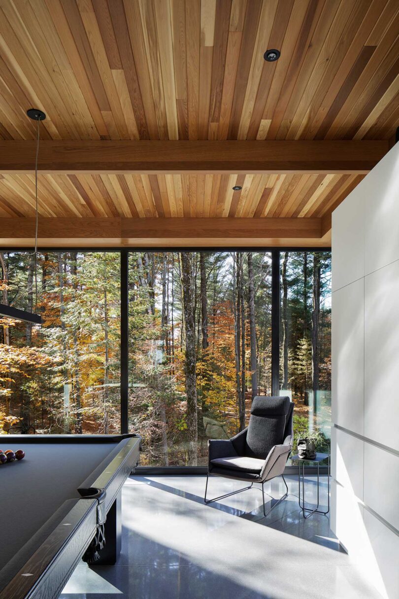 interior view of modern living space with large windows framing wooded view